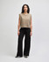 Wide leg pants in black worn with a fitted white long-sleeve top. Features a drawstring waist and a logo.
