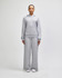 Grey wide-leg pants paired with a matching hoodie, featuring a logo, modelled by a standing woman.