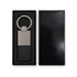 A sleek silver keytag with a leather strap, displayed in a black gift box.