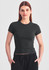 A fitted women's baby tee in dark green with short sleeves, paired with black shorts. It features a subtle logo.