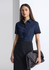 A woman wearing a navy short sleeve shirt, paired with a black skirt and holding a large handbag.