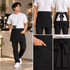 A black half bib short apron with a pocket, featuring a tied back and worn by a person holding a drink.