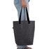 A grey tote bag with black handles, being held by a person wearing blue jeans. The bag has a logo.