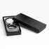 A silver keychain displayed in a black gift box, featuring a sleek design and a glossy finish.