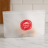 A clear PEVA reusable food storage bag with a red logo, featuring a zip seal and measuring 21.5cm x 12cm.