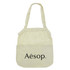 A light beige cotton shopping tote with a mesh top section and a logo on the front.