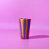 A drink bottle with vibrant orange and purple stripes against a pink background. It has a logo on it.