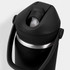 A drink bottle in black with a flip straw and metal trim, featuring a handle and a logo.