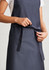 A navy blue Urban Bib Apron featuring a front pocket and adjustable tie at the waist, with branding visible.