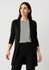 A black longline cardigan with an open front, worn over a striped top and paired with black pants.
