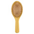 A bamboo hair brush in a light brown hue featuring a smooth handle and rounded bristles.