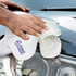 A polishing cloth with a logo is being used on a car's surface.