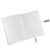 An open notebook with lined pages, featuring a ribbon bookmark and a silver pen. The notebook has a logo on the cover.
