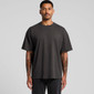 An oversized black t-shirt on a model with tattoos, featuring short sleeves and a relaxed fit. 