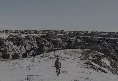 Man walking on barren landscape.