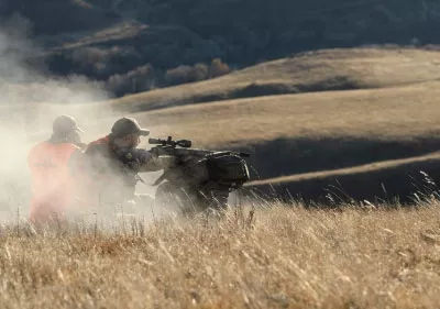 Hunters shooting in field.