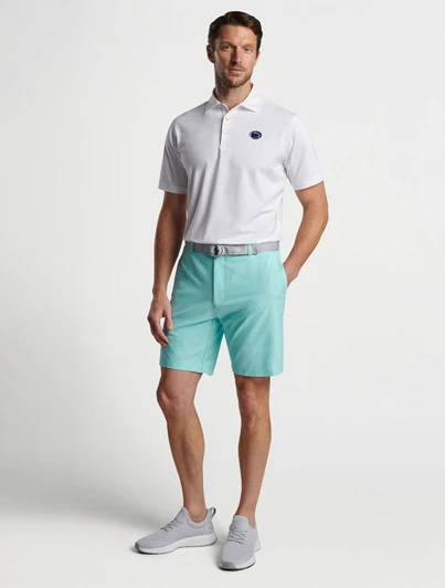Peter Millar white classic fit polo shirt on a man with light blue shorts and gray shoes.