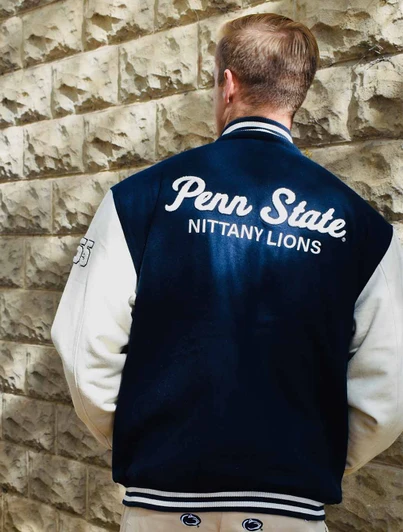 Penn State Nittany Lions varsity jacket, navy blue with white sleeves and embroidered logo details.