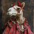Lady Camel wearing a detailed, traditional outfit with a red, textured fabric a