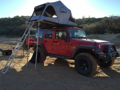  Red Jeep Wrangler with James Baroud soft shell rooftop tent and telescoping ladder