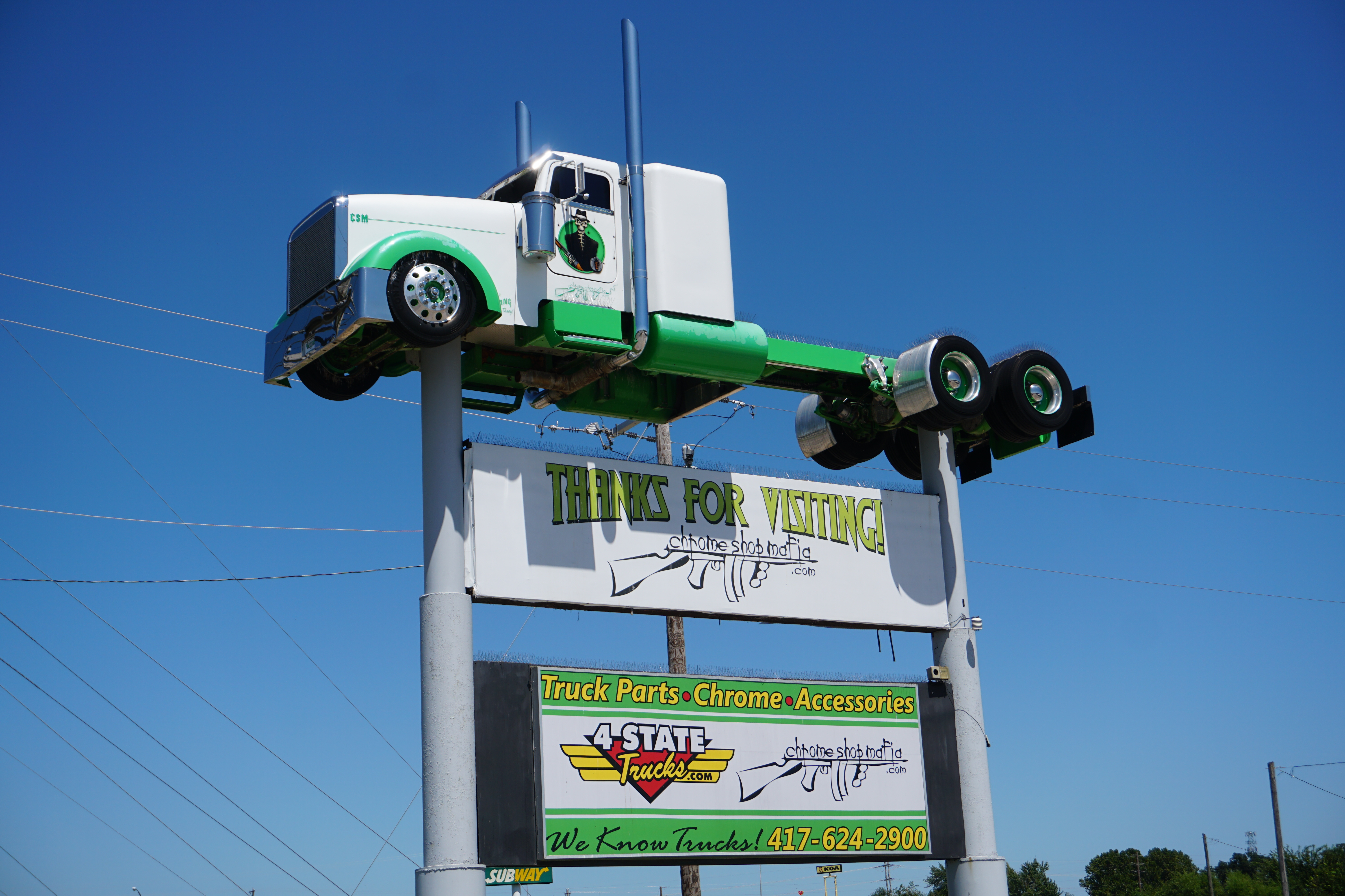 4 State Trucks road sign in front of store with The Mob Sled from Trick My Truck displayed above Chrome Shop Mafia and 4 State Trucks signs