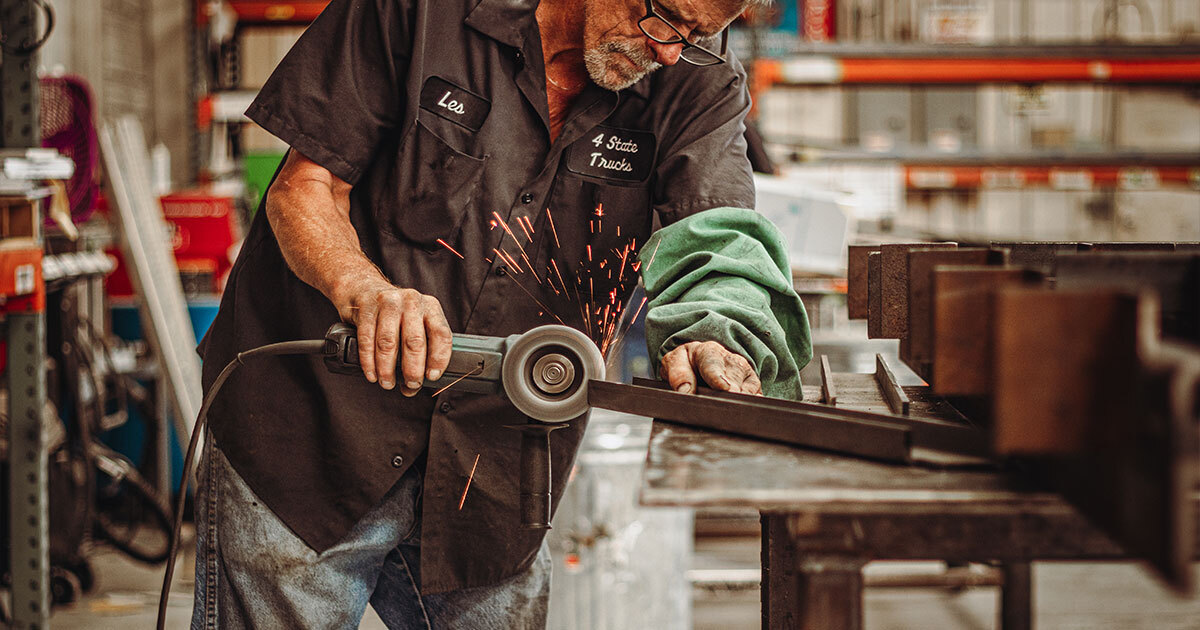 Chrome Shop Mafia worker grinding metal in 4 State Trucks shop creating custom chrome truck parts