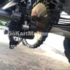 Product ASSEMBLED TrailMaster Mini XRX/R+ Go Kart with Reverse, close-up image of the chain and gear mechanism showing detailed engineering and mechanical components.