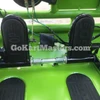 Assembled TrailMaster Mini XRX/R+ Go Kart with Reverse, featuring a bright green frame, black acceleration pedal covers, and metal suspension components for children aged 4 and up.
