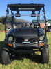 Trailmaster Taurus 200U Utility SXS UTV, black outdoor utility vehicle with sturdy frame, large tires, and front bumper, parked on grass under clear sky.