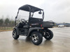 Trailmaster Taurus 200U, utility SXS UTV, black off-road utility vehicle with cargo bed and rugged tires on a concrete surface.