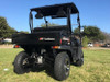 Trailmaster Taurus 200U Utility SXS UTV, black recreational off-road vehicle with large tires and open cargo bed on a grassy field.