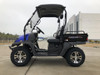 Trailmaster Taurus 200U Utility SXS UTV, side view of rugged utility vehicle with black tires and a cargo bed, parked outdoors near a modern building.