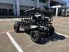 TrailMaster Cheetah 300Pro Premium EFI Go-Kart/UTV Crossover, rugged off-road vehicle with large tires and spare tire mounted on the rear, parked in a commercial parking lot.