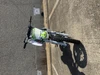 TrailMaster SK110A 110cc Fully Automatic Kids Dirt Bike, front view showing green and white color with black tires on asphalt ground.