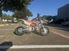 TrailMaster SK110S 110cc Semi-Automatic Kids Dirt Bike, colorful off-road motorcycle in a parking lot under a clear blue sky.
