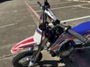 TrailMaster SK110S 110cc Semi-Automatic Kids Dirt Bike, close-up view showing the handlebars, front suspension, and colorful graphics on the frame.