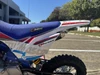 TrailMaster SK110S 110cc Semi-Automatic Kids Dirt Bike, close-up of the blue seat, white frame, and red and black accents on the bike.