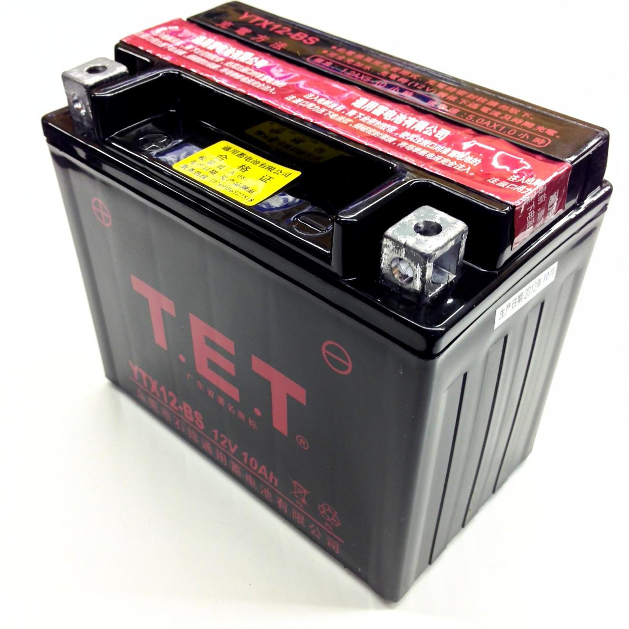 TrailMaster 200 XRS & 200 XRX & 200e XRS with EFI battery, a black automotive battery with pink and yellow labels, and metal terminals on the top.