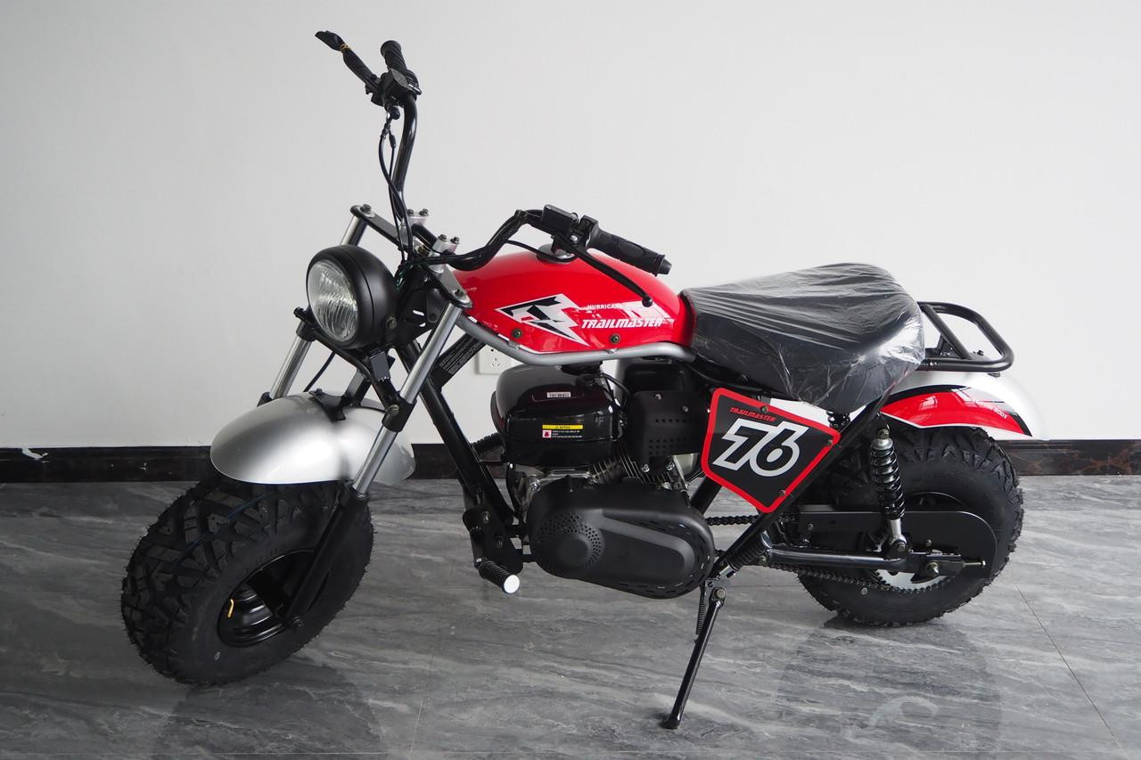 TrailMaster Hurricane 200X Mini Bike, red and black mini bike with large black tires, front headlight, and racing number 76 on side panel, indoor setting.