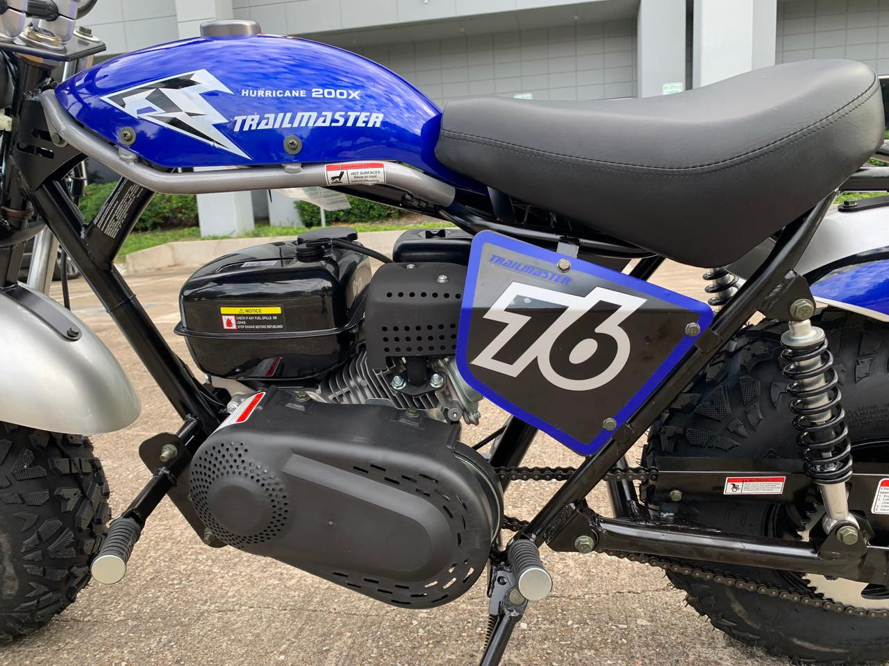 TrailMaster Hurricane 200X Mini Bike, close-up view of the blue gasoline-powered mini motorcycle with racing number 36 on the side panel, black engine, and rugged tires.