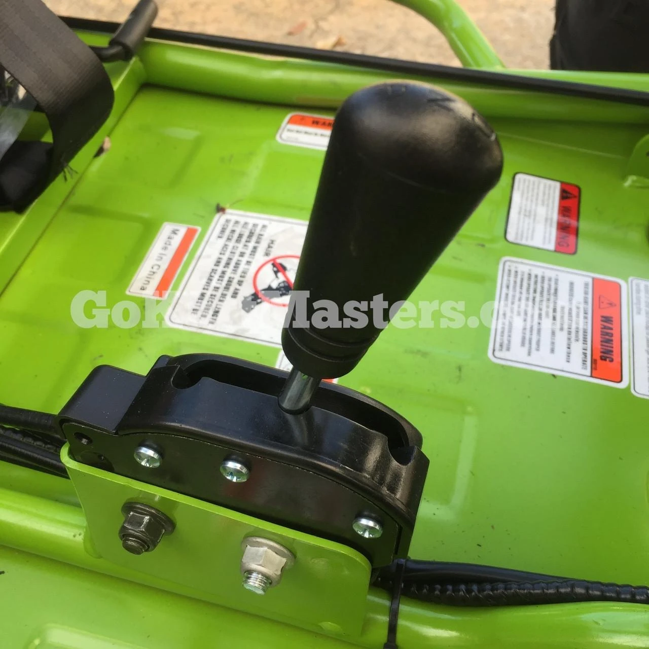 Product ASSEMBLED TrailMaster Mini XRX/R+ Go Kart with Reverse - View of the gear shift lever on the green go-kart for young children aged 4 and above.
