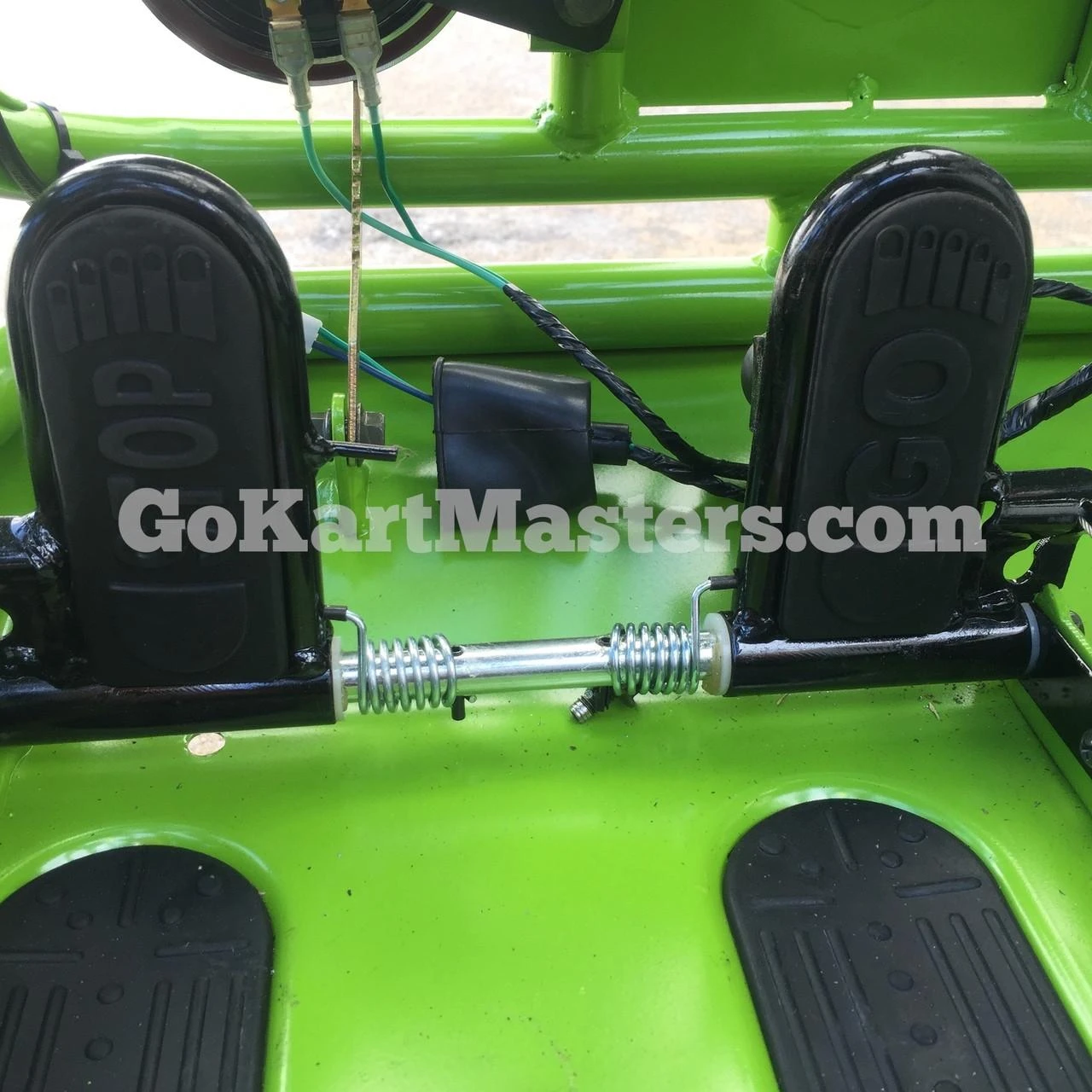 Assembled TrailMaster Mini XRX/R+ Go Kart with Reverse, featuring a bright green frame, black acceleration pedal covers, and metal suspension components for children aged 4 and up.