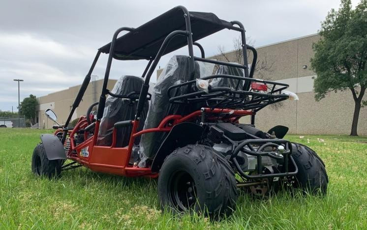 TM 300 XRS-4E 4 Seater Go Kart for Families, red off-road go-kart with four seats, roll cage, and large tires, parked on grass near a building and trees.