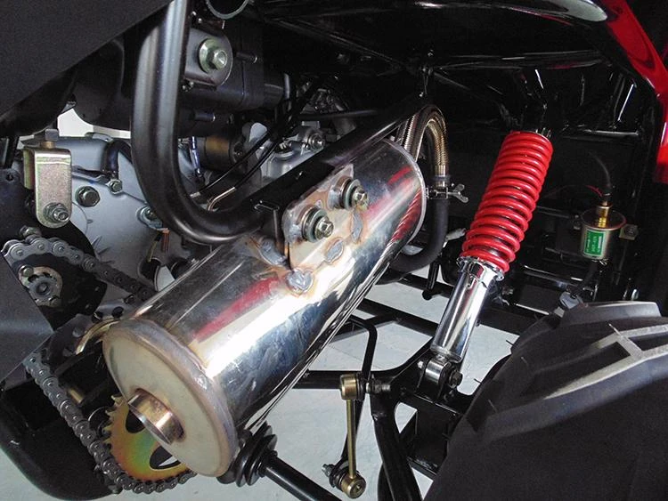 Trailmaster Challenger 300 EX 300cc SXS, close-up of the vehicle's engine and suspension system showing a shiny metal exhaust and red coil shock absorber.