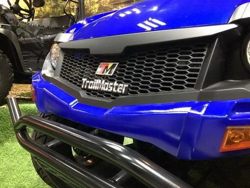 Trailmaster Taurus 200U, close-up of the front of the utility UTV with a black honeycomb grille, blue body, and chrome bumper.
