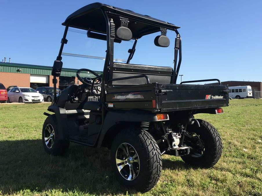 Trailmaster Taurus 200U, utility side-by-side UTV with a cargo bed, black color, two-seat design, off-road tires, and a protective roof, suitable for farm and outdoor work.