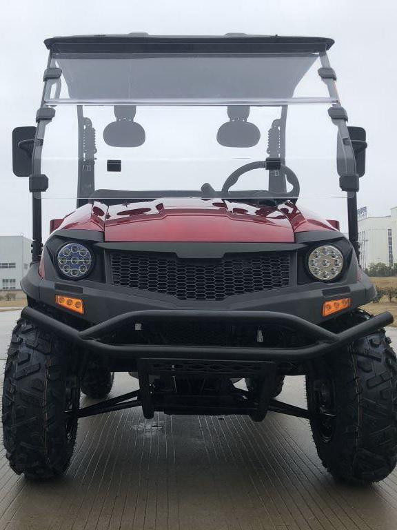 Trailmaster Taurus 200U Utility SXS UTV, front view of red and black all-terrain vehicle with rugged tires, headlamps, and a clear windshield.