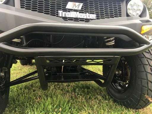 Trailmaster Taurus 200U |Utility | SXS | UTV, close-up view of the front of the vehicle showing the bumper and tire on a grassy surface.