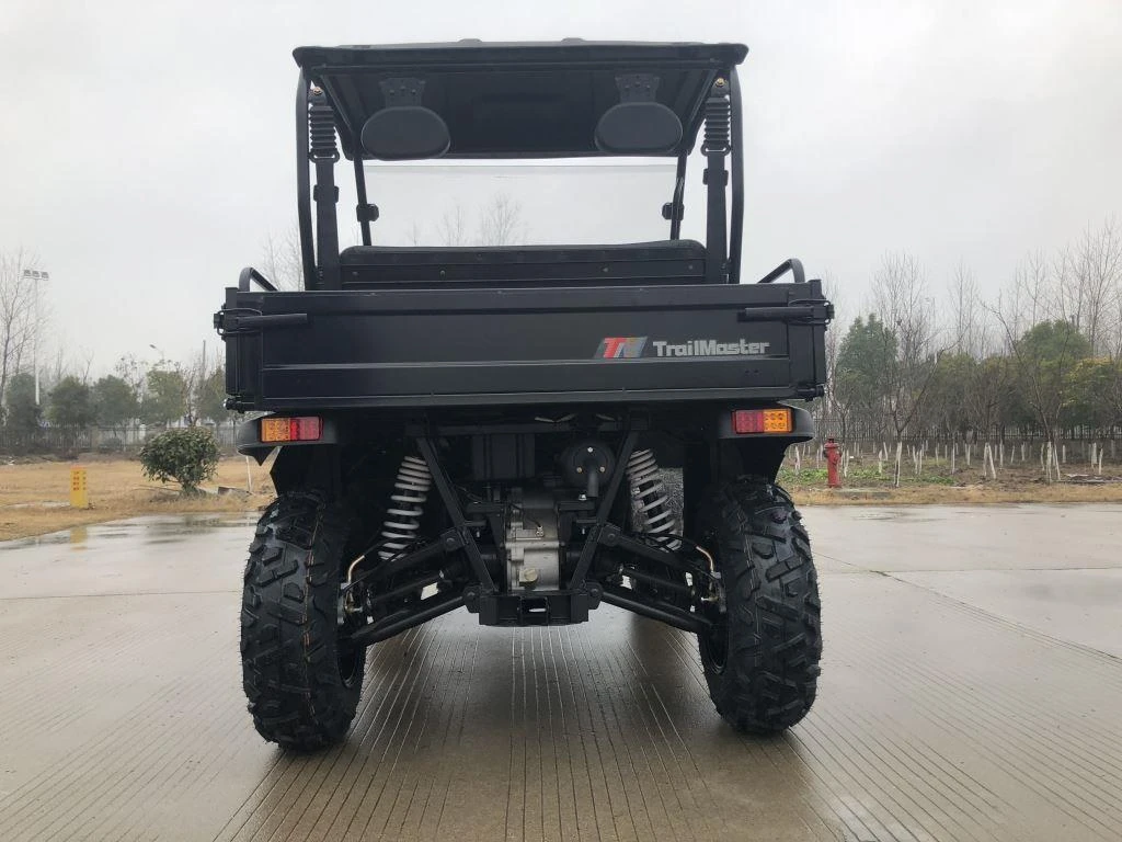 Trailmaster Taurus 200U utility side-by-side vehicle, front view showing rugged tires, suspension, and cargo bed with brand logo, suitable for off-road utility tasks.