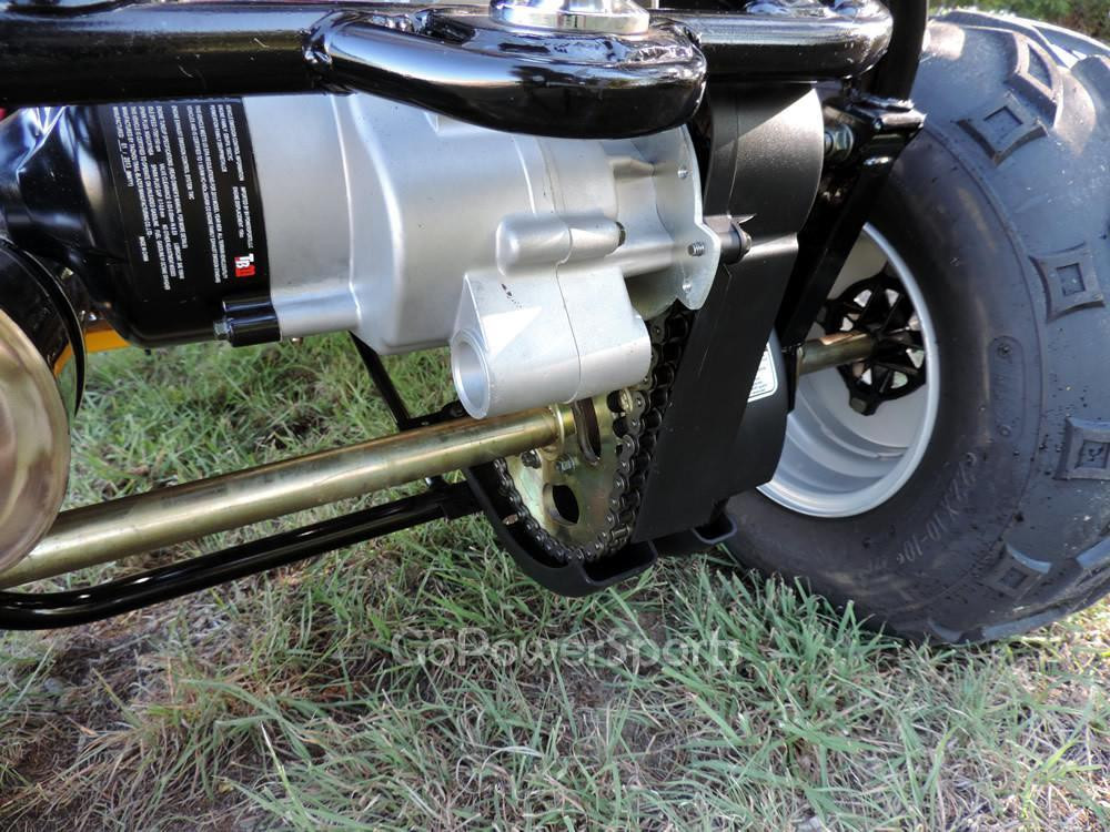 TrailMaster 200 XRS Go Kart with Carburetor, close-up of engine and chain drive system on rugged grass terrain.